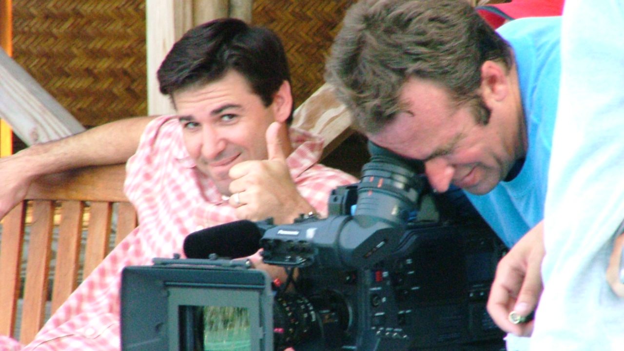 Handsome Man gives thumbs up to camera next to movie director looking into ARRI Alexa viewfinder