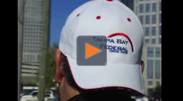 Guy wearing Tampa Bay Federal Credit Union hat backwards while riding a motorcycle